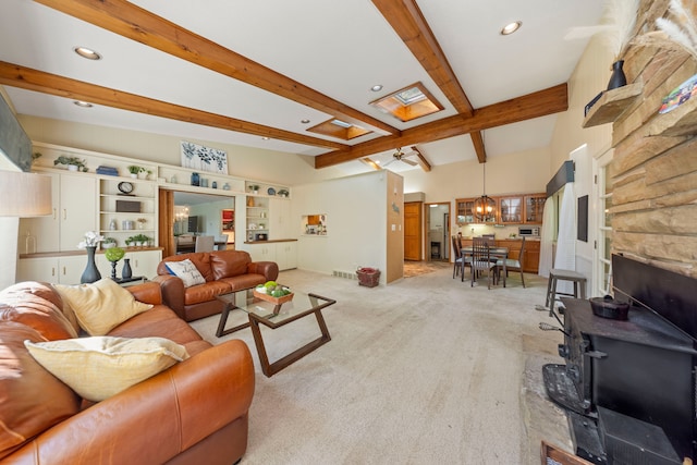 carpeted living room featuring lofted ceiling with beams