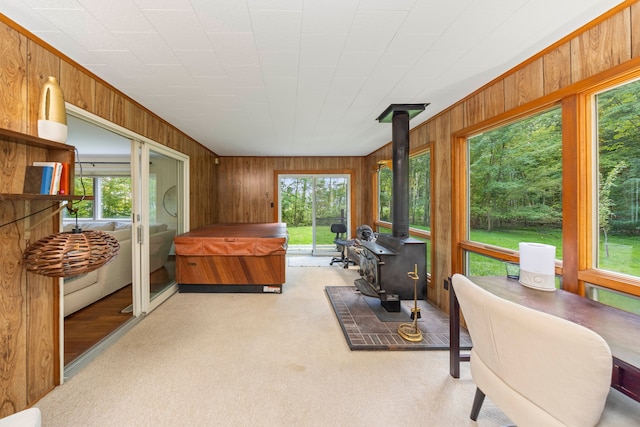 sunroom / solarium featuring a wood stove and a wealth of natural light