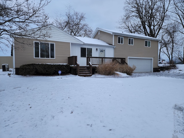 view of front facade featuring central air condition unit, a wooden deck, and a garage