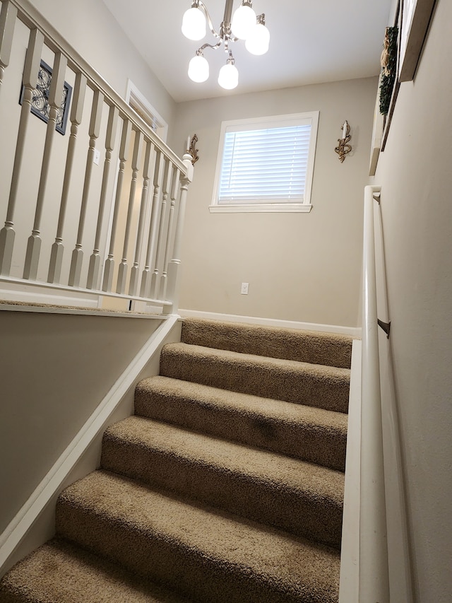 staircase featuring a chandelier