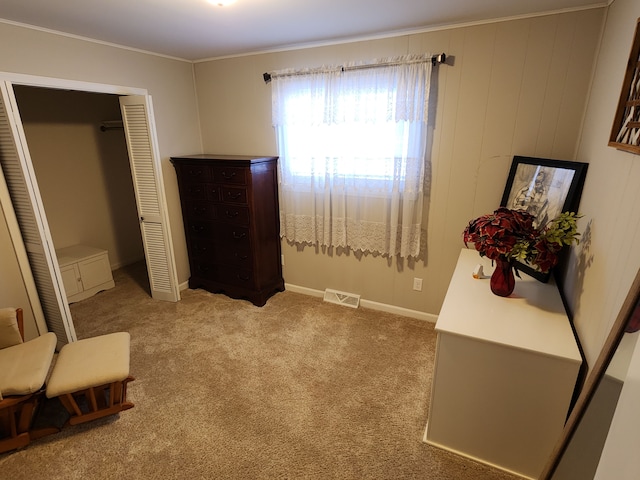 bedroom featuring crown molding, light carpet, and a closet