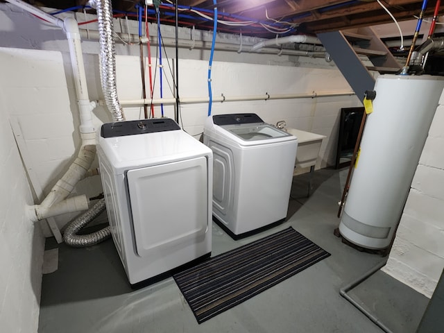 clothes washing area with washer and dryer, gas water heater, and sink