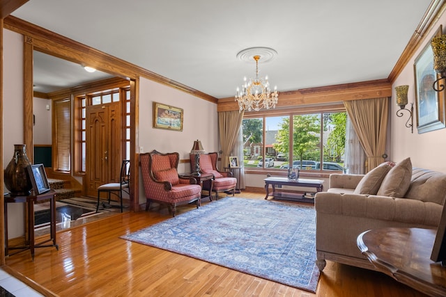 living room featuring crown molding, hardwood / wood-style floors, and an inviting chandelier