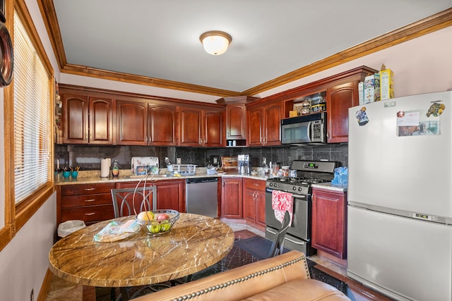 kitchen with light stone countertops, appliances with stainless steel finishes, backsplash, and crown molding