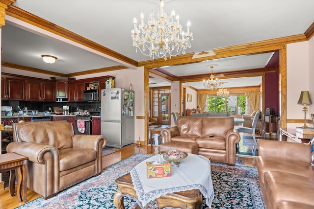 living room with light hardwood / wood-style floors, a notable chandelier, and ornamental molding