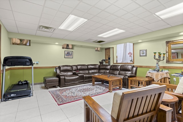 tiled living room with a paneled ceiling