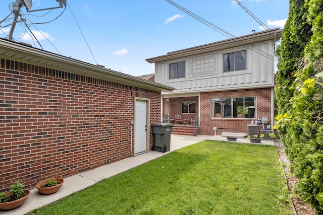 rear view of house featuring a lawn and a patio