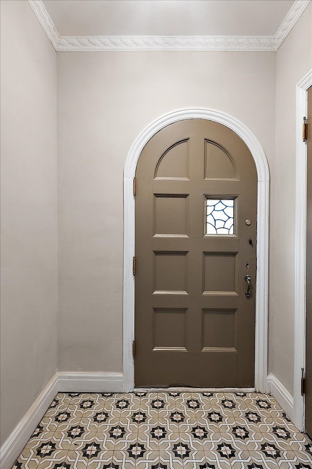 tiled entrance foyer featuring crown molding