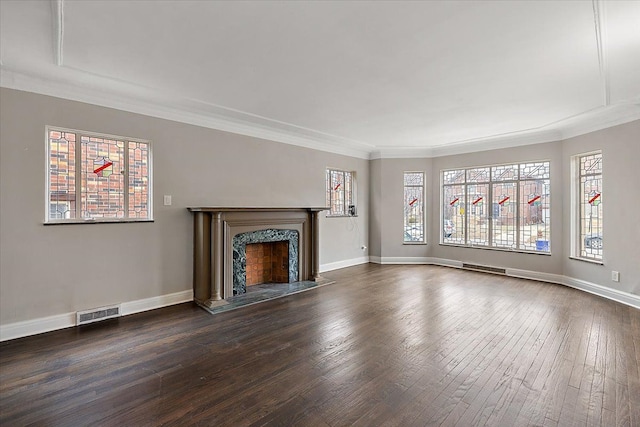 unfurnished living room featuring a wealth of natural light, crown molding, a high end fireplace, and dark hardwood / wood-style floors