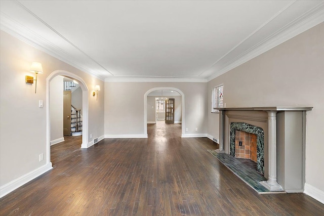 unfurnished living room with a tile fireplace, crown molding, and dark hardwood / wood-style flooring