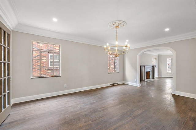 unfurnished dining area with dark hardwood / wood-style floors, ornamental molding, and an inviting chandelier