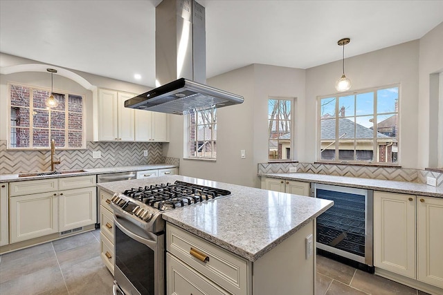 kitchen featuring sink, wine cooler, stainless steel gas stove, light stone countertops, and island range hood