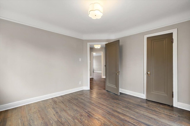 unfurnished room featuring dark hardwood / wood-style floors and ornamental molding