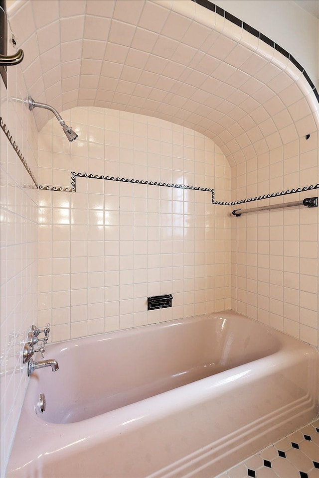 bathroom featuring a washtub and lofted ceiling