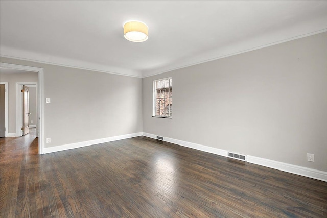 empty room featuring crown molding and dark hardwood / wood-style flooring