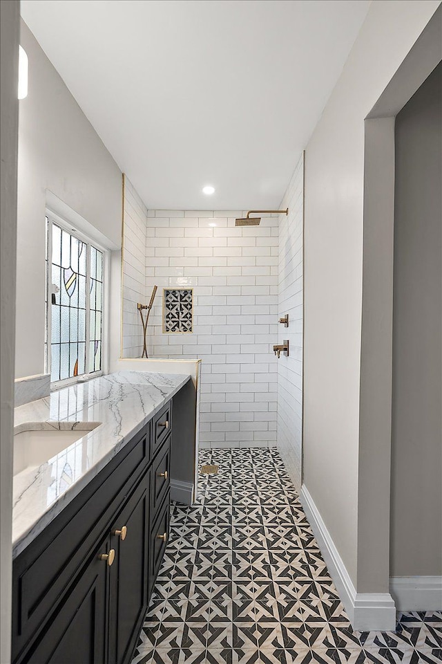 bathroom featuring a tile shower and vanity