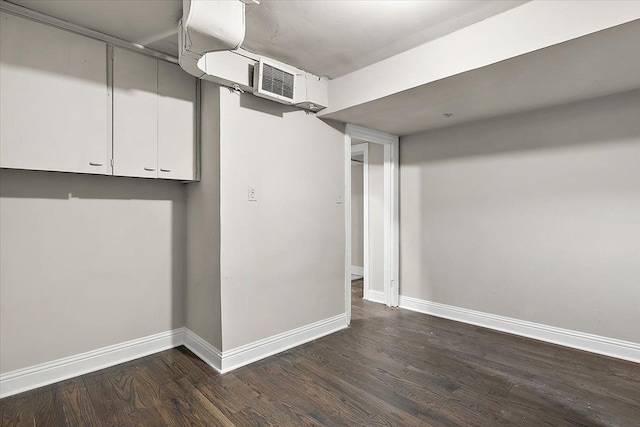 basement with dark hardwood / wood-style floors