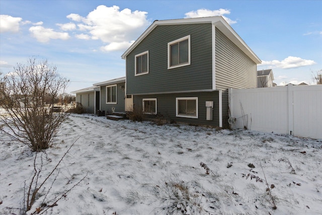 view of snow covered rear of property