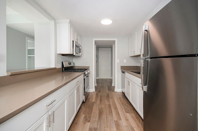 kitchen featuring white cabinets, light hardwood / wood-style floors, and appliances with stainless steel finishes