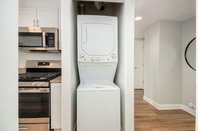 washroom with stacked washing maching and dryer and light wood-type flooring