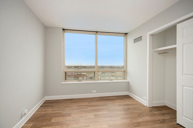 unfurnished bedroom featuring a closet and light hardwood / wood-style floors