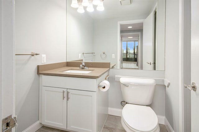 bathroom with tile patterned flooring, vanity, and toilet