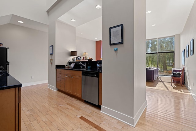 kitchen with black fridge, dishwasher, expansive windows, and light hardwood / wood-style floors