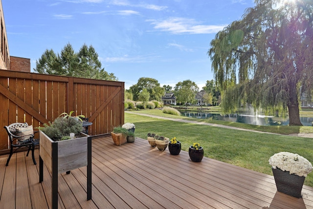 deck with a lawn and a water view