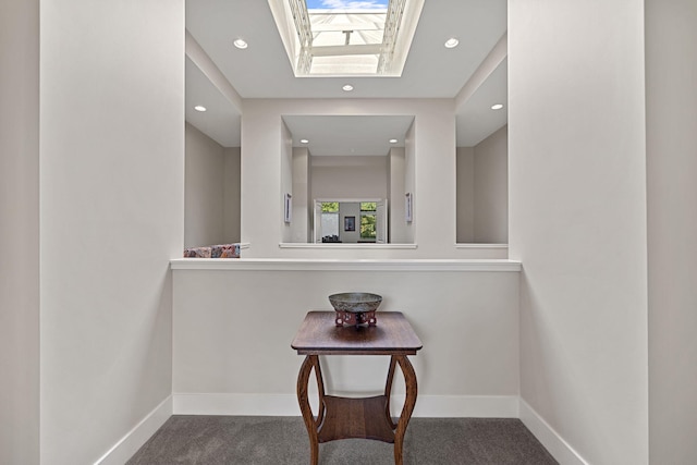 hall with carpet and a skylight