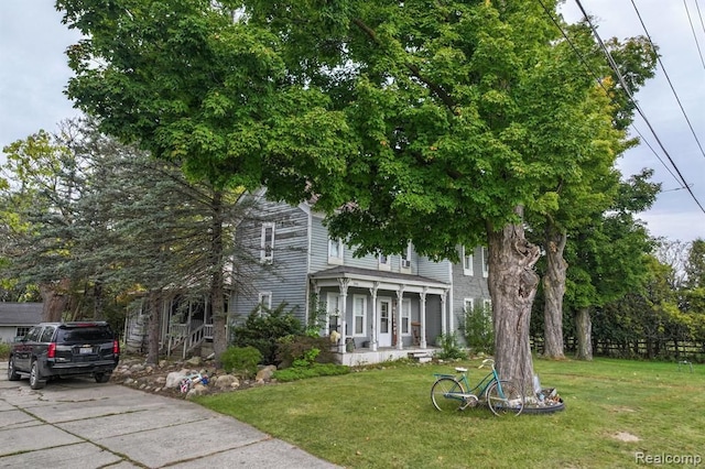 view of front of property featuring covered porch and a front yard