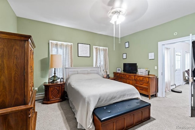 carpeted bedroom with baseboard heating and ceiling fan