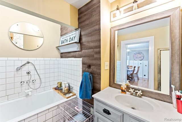 bathroom featuring vanity and tiled tub