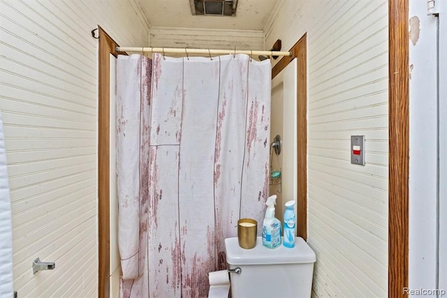 bathroom with curtained shower, toilet, and ornamental molding