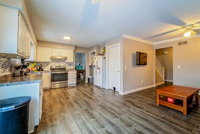 kitchen with white refrigerator with ice dispenser, backsplash, white cabinets, and electric stove