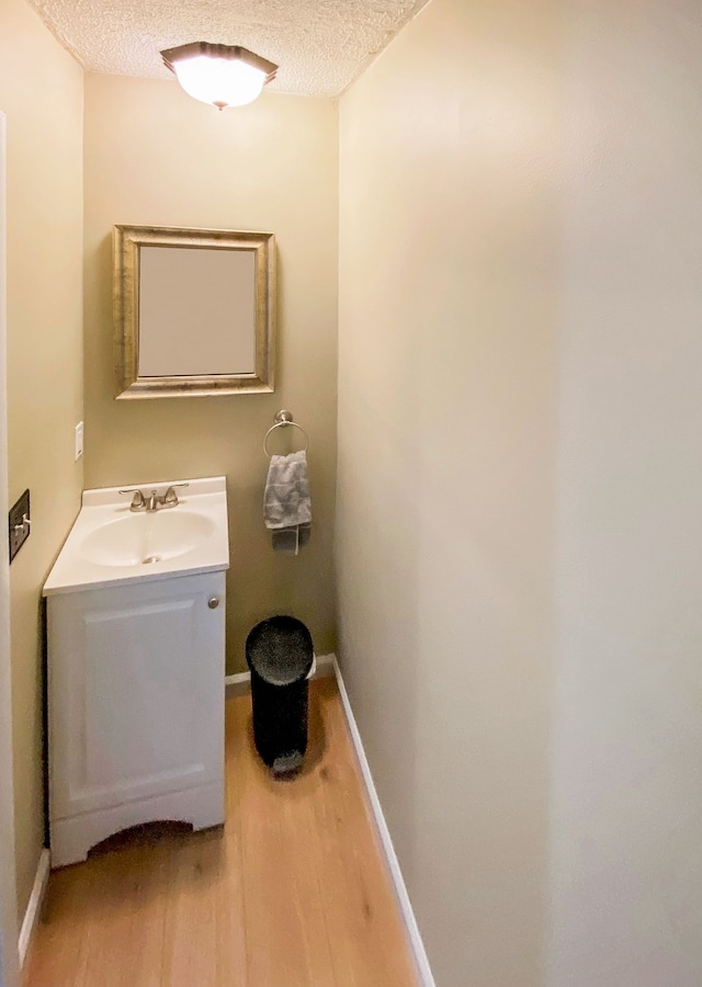 bathroom featuring hardwood / wood-style floors, vanity, and a textured ceiling