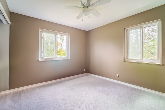 carpeted spare room featuring ceiling fan