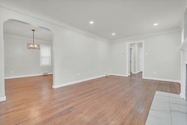 unfurnished living room with a fireplace, hardwood / wood-style flooring, and crown molding