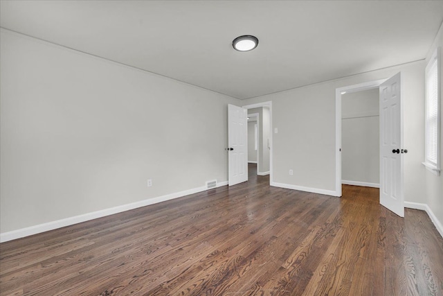 unfurnished bedroom with a closet and dark wood-type flooring