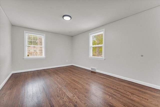 empty room with dark hardwood / wood-style flooring