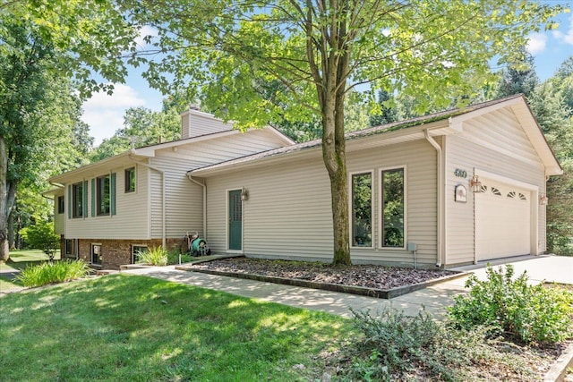 back of house featuring a garage and a lawn