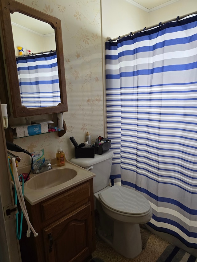 bathroom with toilet, vanity, and ornamental molding