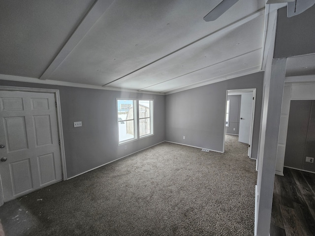 carpeted empty room featuring ornamental molding and vaulted ceiling