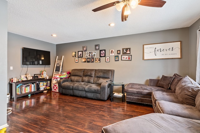 living room with ceiling fan, dark wood-type flooring, and a textured ceiling