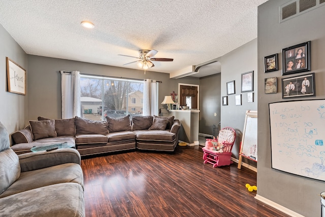 living room featuring a textured ceiling, dark hardwood / wood-style floors, and ceiling fan