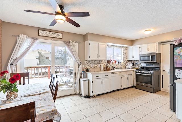 kitchen featuring ceiling fan, white cabinetry, backsplash, and appliances with stainless steel finishes