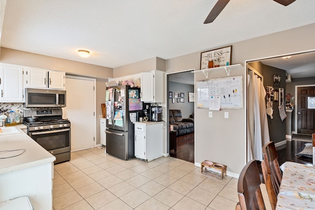 kitchen featuring stainless steel appliances, white cabinetry, and light tile patterned flooring