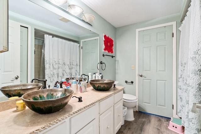 bathroom with curtained shower, hardwood / wood-style floors, vanity, and toilet