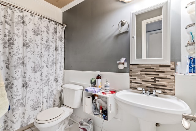 bathroom featuring a shower with shower curtain, backsplash, crown molding, sink, and toilet