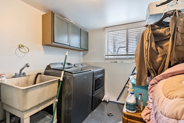 laundry area featuring cabinets, washer and clothes dryer, and sink