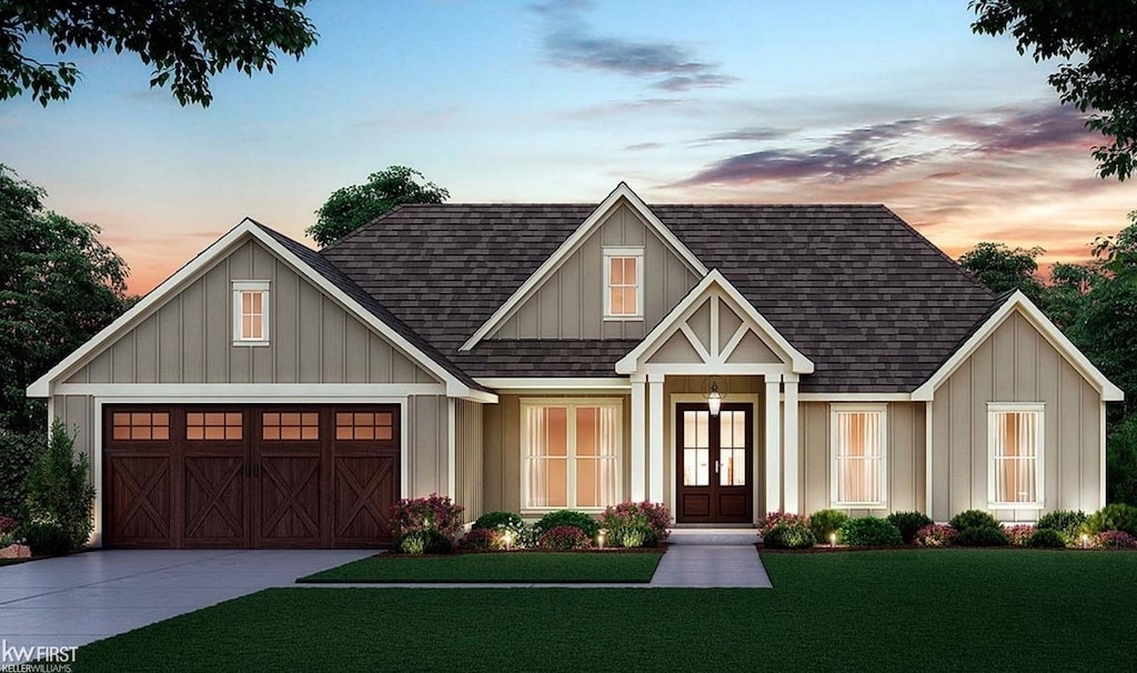 view of front of home with a garage, a yard, and french doors